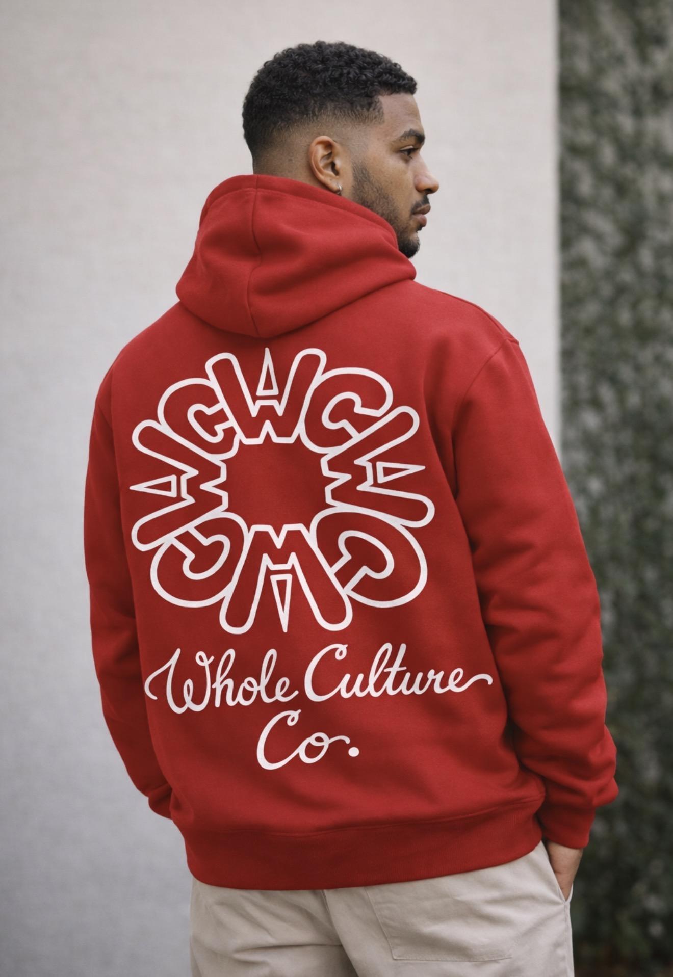 Model wearing the WCWC Circle Logo Hoodie in brick red, outdoor studio setting